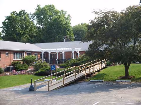 Brick building of Palmer Healthcare Center with a wooden ramp leading to the entrance.