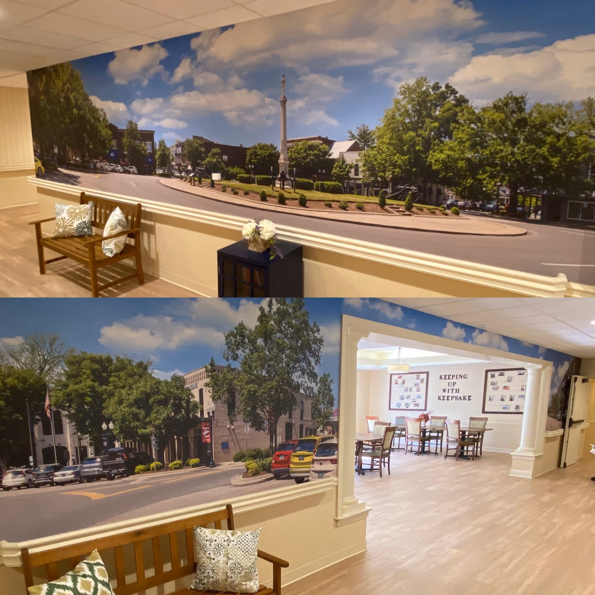 Interior hallway of Vitality Living Franklin featuring large wall murals depicting outdoor street scenes with trees, buildings, and cars. The hallway includes wooden benches with decorative pillows and a small table with a flower arrangement. In the background, there is a seating area with tables and chairs and a wall display titled 'KEEPING UP WITH KEEPSAKE'.