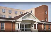 Front entrance of Heritage Center building with brick walls, glass doors, and a peaked porch.