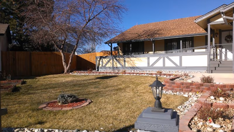 Front view of a single-story assisted living residence with lawn, walkway, and covered porch.