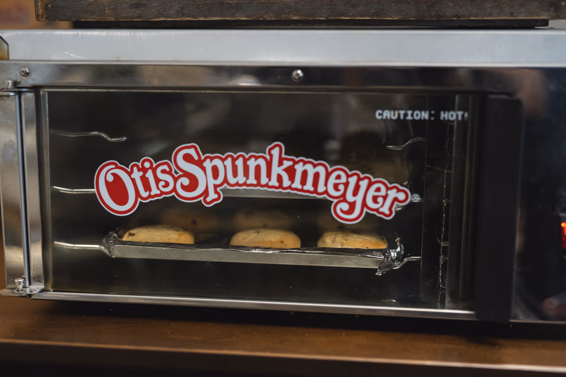 A countertop warming oven with an Otis Spunkmeyer logo and cookies baking inside.