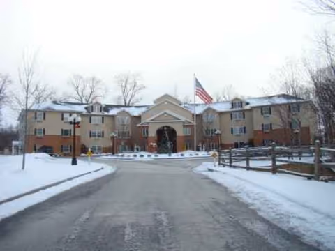 Snowy exterior of Hart Heritage Estate senior living facility with flag.