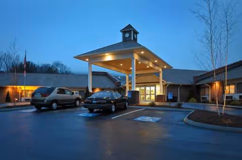 Front entrance of Life Care Center of Banner Elk with a porte-cochere and parked cars.