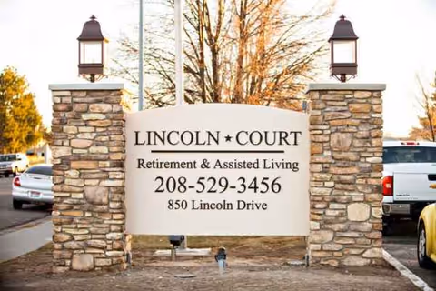 Stone pillars frame a sign reading Lincoln Court Retirement & Assisted Living.