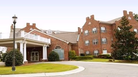 Brick senior living facility with curved driveway and entrance portico.