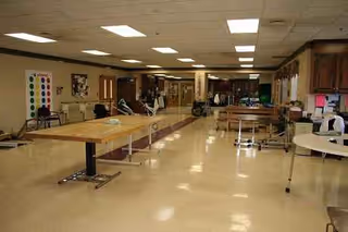 Interior of a senior facility dining area with long tables and chairs.