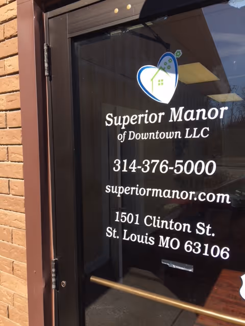 Glass entry door displaying the Superior Manor of Downtown LLC logo and contact information including phone, website, and address.