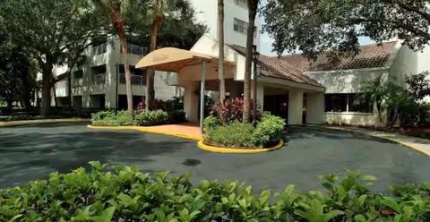 Exterior view of Belleair Towers entrance with a canopy and landscaped drive.