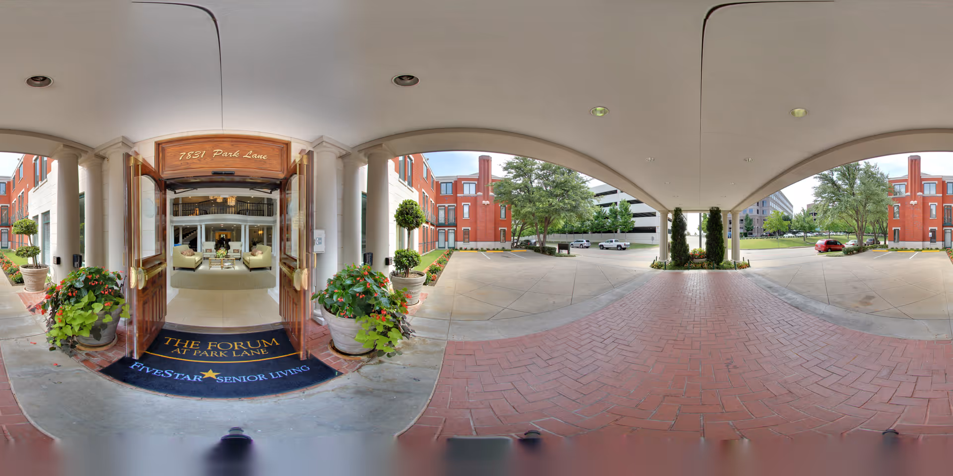 Covered porte-cochère and open double-door entrance to The Forum at Park Lane senior living facility with potted plants and a view into the lobby.