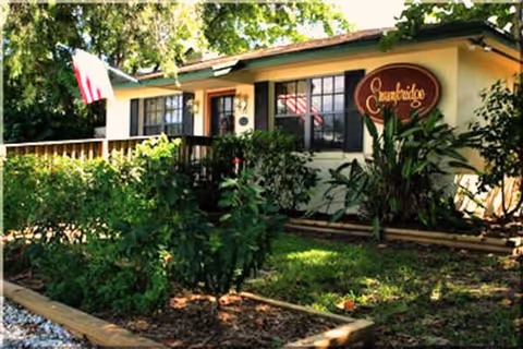 Exterior view of Swankridge Care Center showing front entrance, sign, and surrounding plants.