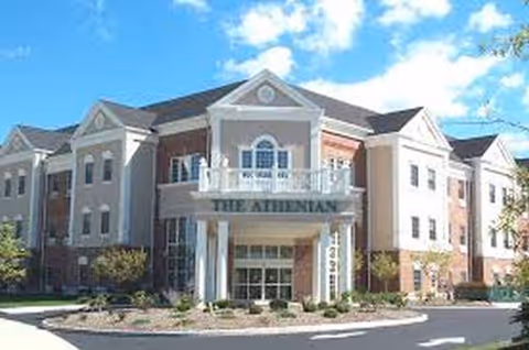 Two-story senior living facility with a central entrance and columned façade.