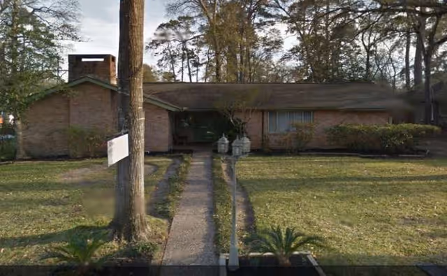 Single-story brick senior care facility with a front walkway and trees.