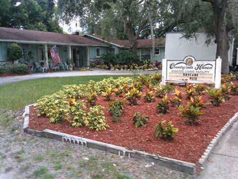Exterior view of Countryside Haven with a landscaped flower bed and building entrance.