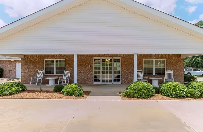 Front view of Countryside Senior Living building with porch chairs and greenery.