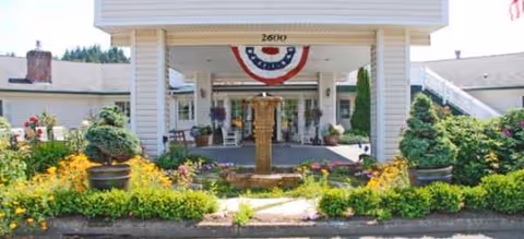 Entrance to Brookdale Fairhaven with a fountain, garden, and patriotic bunting.