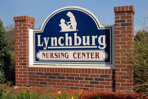 Outdoor brick sign for Lynchburg Nursing Center with blue emblem.