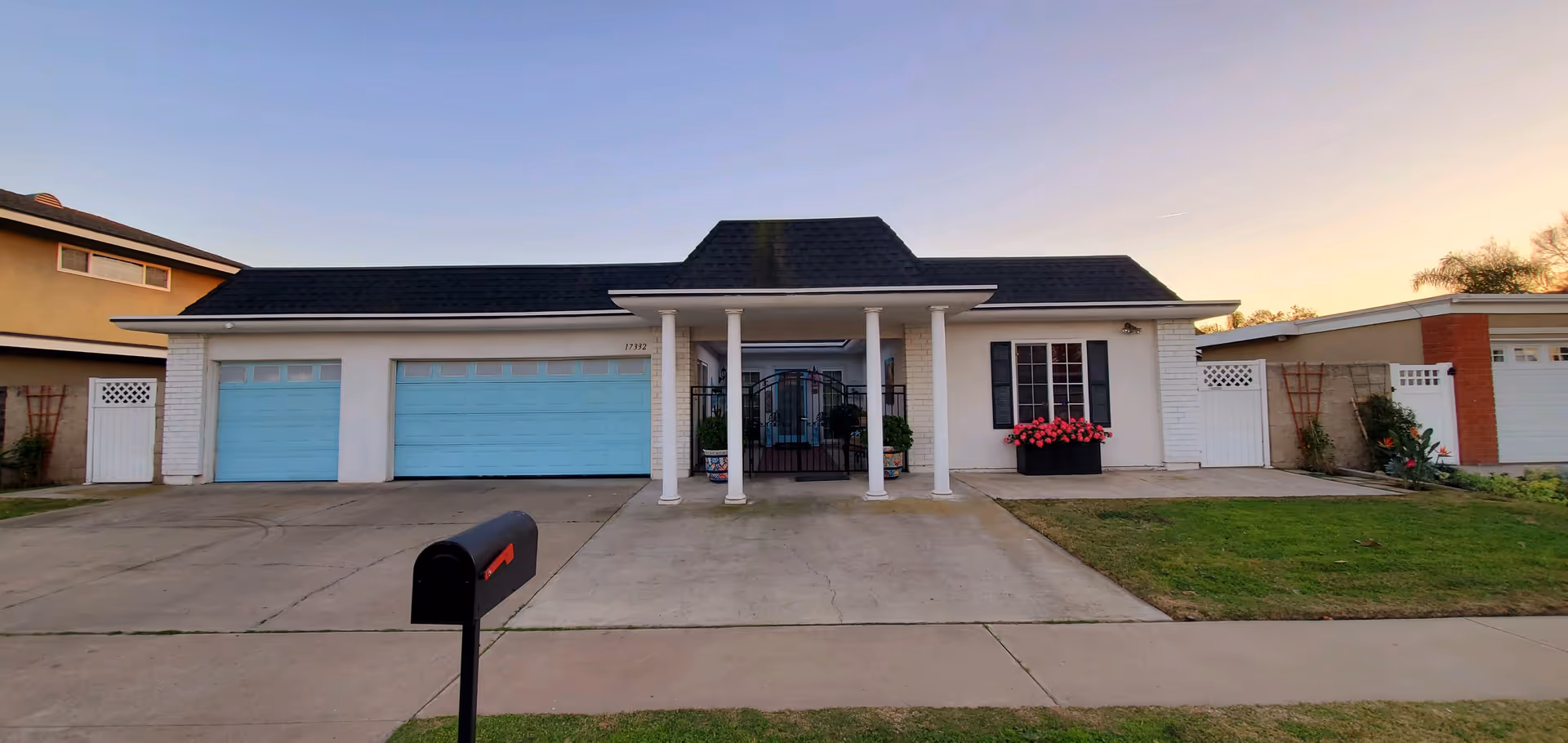 A single-story senior living home with blue garage doors and a central front porch.