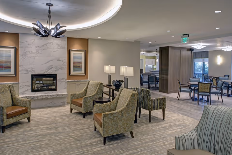 Revitz House lounge with fireplace, chairs, lamps, and dining area.