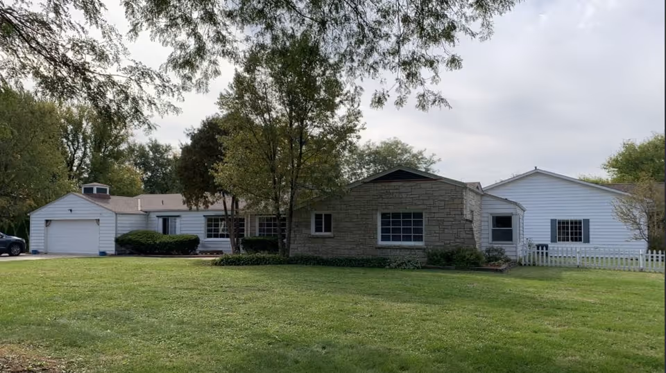 Exterior view of The Heathers - Ringwood, a single-story building with stone facade and lawn.