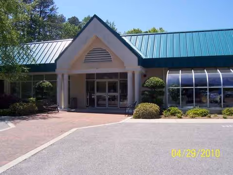 Front view of Lancashire Nursing and Rehabilitation Center entrance with glass doors and landscaping.