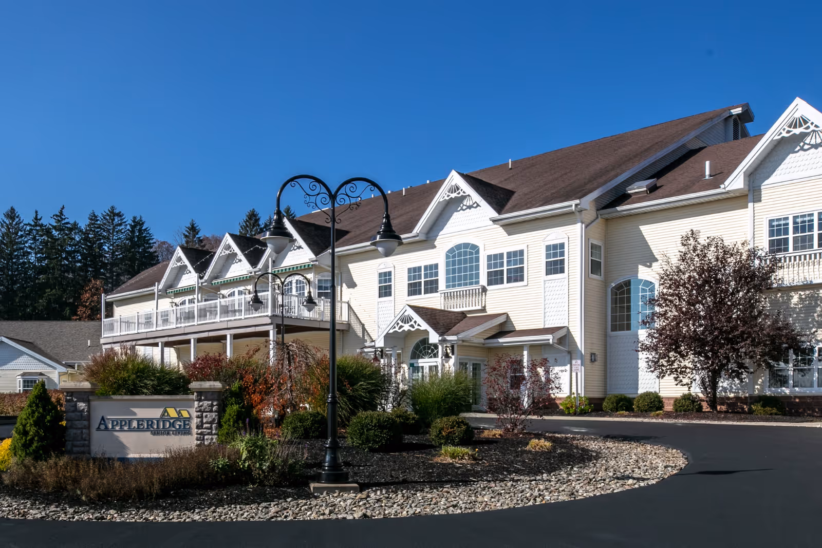 Front exterior of the Appleridge Senior Living building with landscaped entrance, signage, and a decorative lamp post.