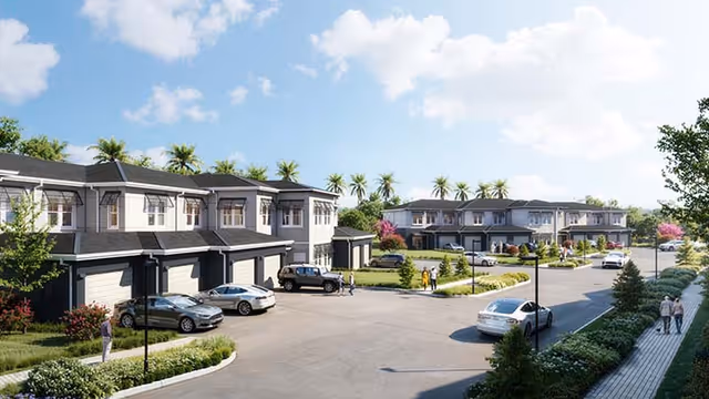 View of a residential community with two-story townhouses, cars parked in driveways, and people walking along a sidewalk. The area is landscaped with trees, bushes, and palm trees under a partly cloudy sky.