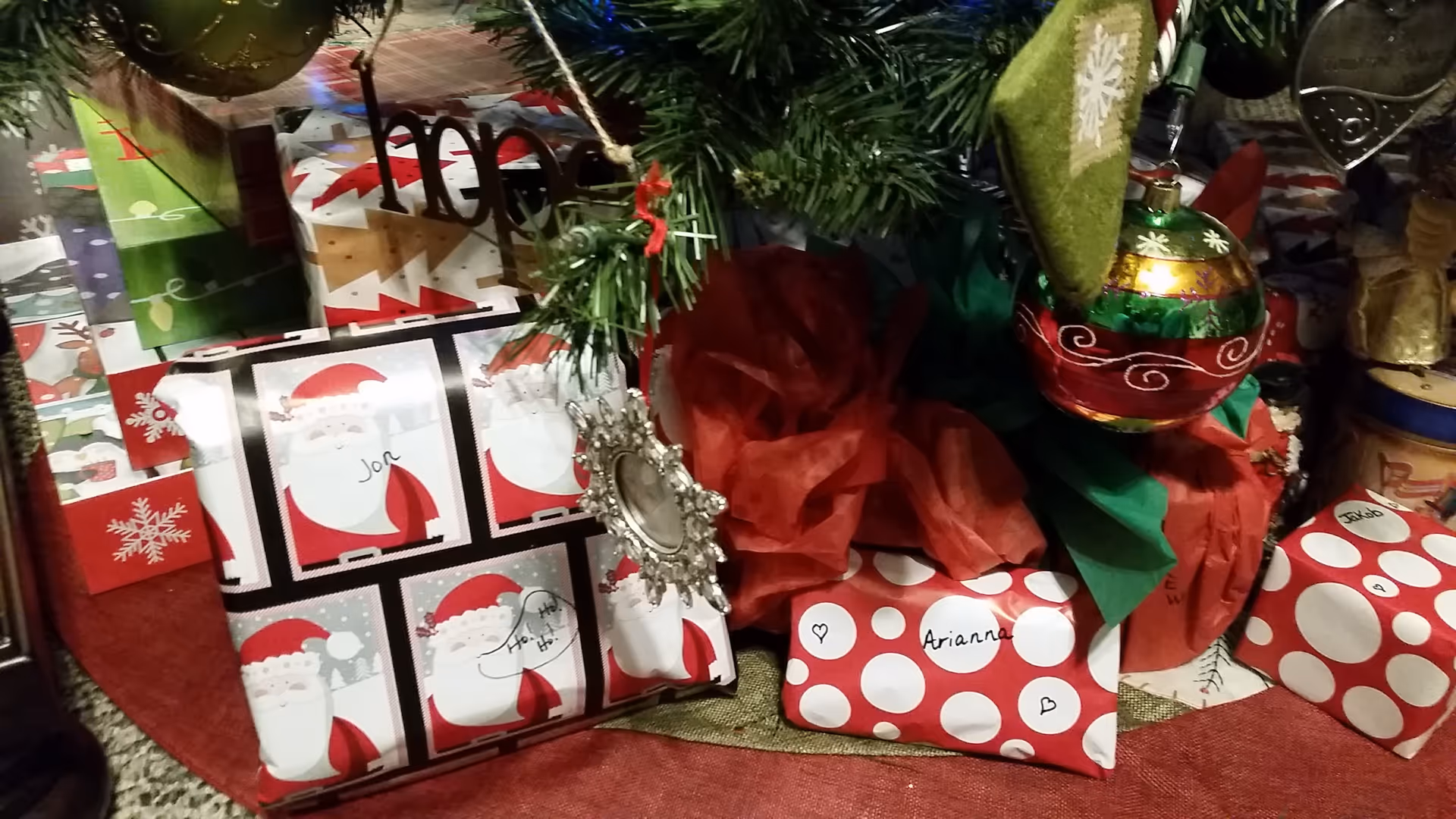 A holiday scene with wrapped gifts and ornaments under a Christmas tree.