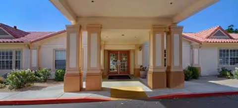 Covered entrance with columns at Brookdale Arrowhead Ranch leads to double doors.