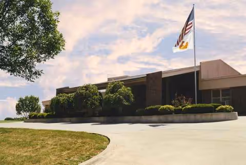 Front exterior view of Life Care Center of Grandview with flag and landscaped entrance.