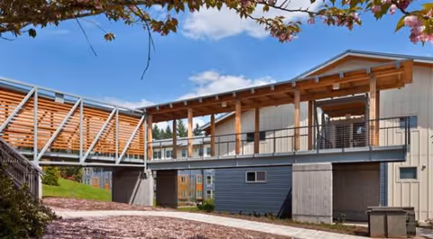 Exterior view of Creekside Woods facility with a covered walkway and modern siding.