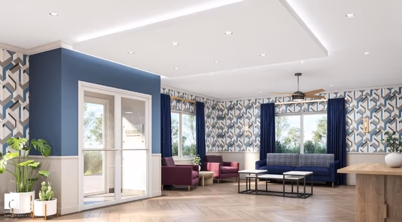 Bright modern communal lounge with patterned wallpaper, sofas and armchairs arranged around coffee tables, large windows, and a double glass entrance door.