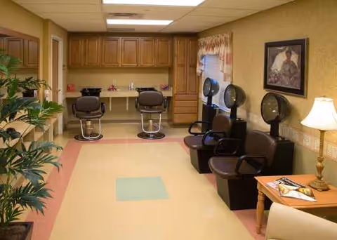 Interior of a senior living facility salon with styling chairs and cabinets.