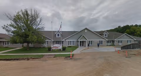 Exterior view of Sienna Crest Assisted Living building with entrance and driveway.