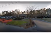 Exterior view of Oakbrook Health and Rehabilitation Center with parking and entrance.