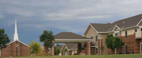 Exterior view of Christian Homes Care Community, brick building with a covered entry and surrounding trees.
