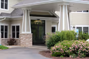 Front entrance of Riverbend Assisted Living with a covered porte-cochere and landscaping.