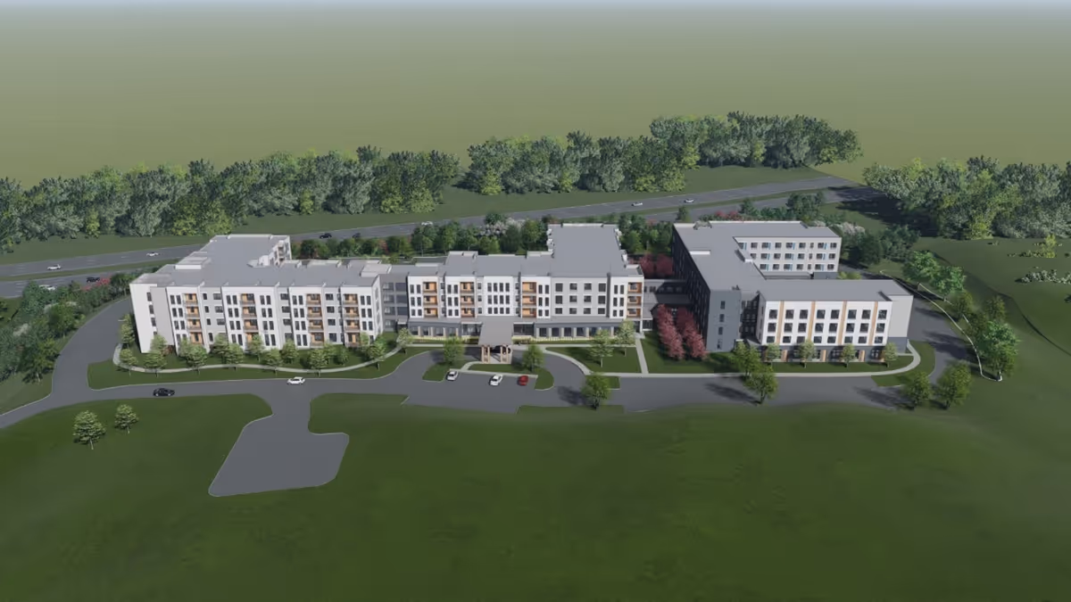 Aerial architectural rendering of a multi-wing, multi-story senior living building surrounded by driveways, parking areas, and landscaped lawns.