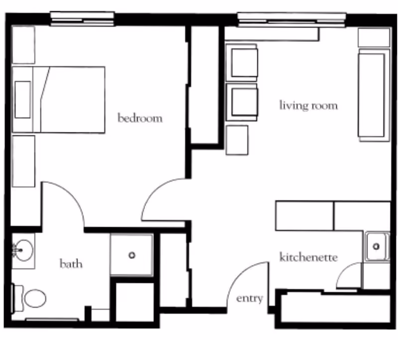 Floor plan of a living space showing a bedroom with a bed and two side tables, a bathroom with a toilet and sink, a living room with seating furniture, and a kitchenette with a sink and counter space. The entry door opens into the kitchenette and living room area.