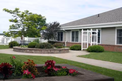 Exterior view of Father Baker Manor with a circular brick planter and walkway.