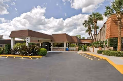 Exterior view of Life Care Center of Altamonte Springs with a covered entrance and palm trees.