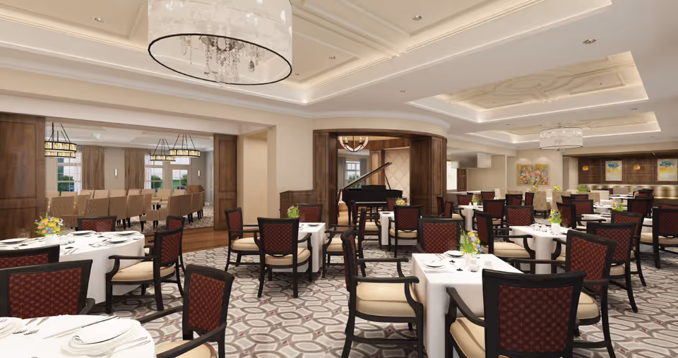 Spacious elegant dining room with white-clothed tables and upholstered chairs, chandeliers, wood accents, and a black grand piano.