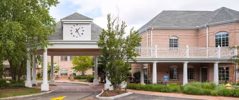 Exterior view of Autumn Lake Healthcare at the Willows with brick building and clock tower.