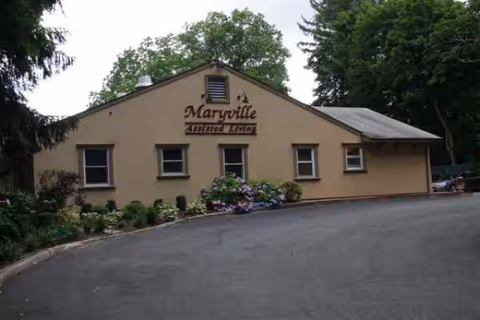 Beige single-story building with a front sign reading Maryville Enhanced Assisted Living Center.