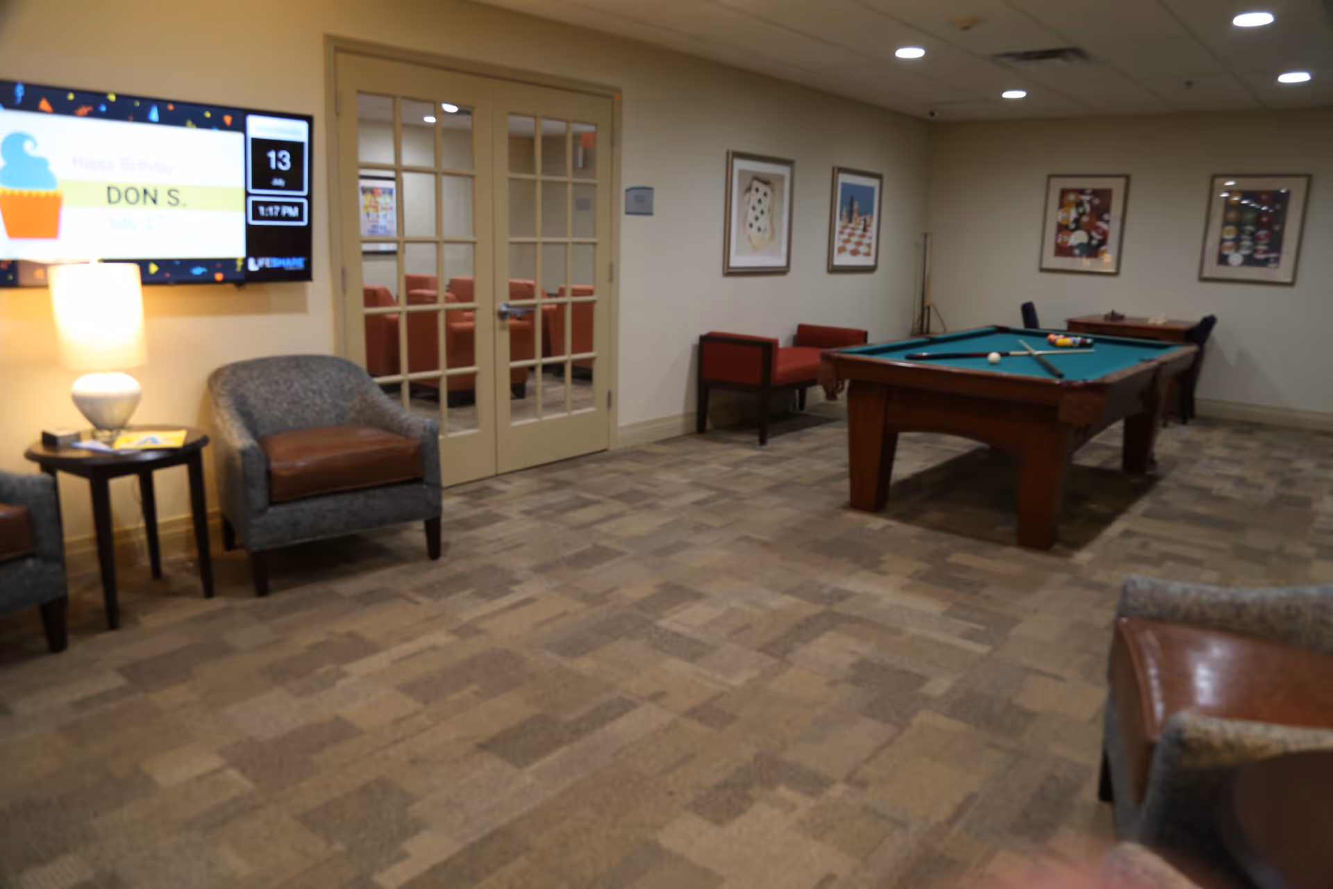 Common area with a pool table, seating, and a wall-mounted TV.