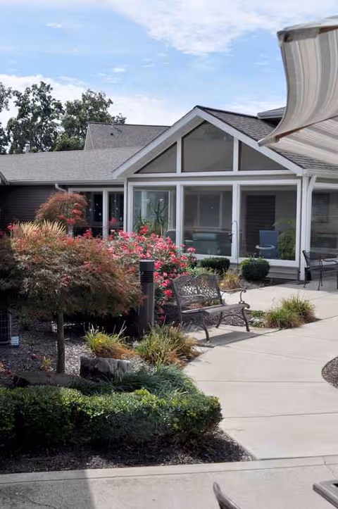 Exterior view of Woodview A Waters Community with benches and landscaped courtyard.