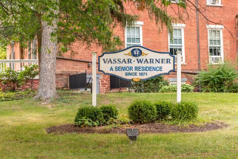 Exterior view of Vassar-Warner senior residence sign in front of brick building.