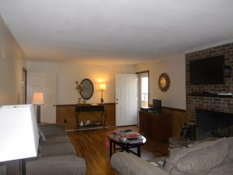 Cozy living room in a senior facility with sofa, coffee table, and fireplace.