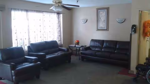 Cozy senior living room with leather sofas, a coffee table, and a large window.