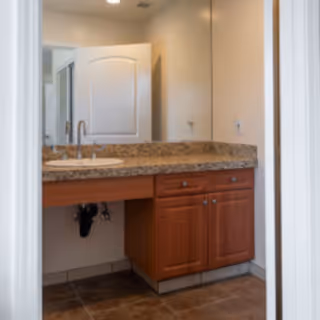 Bathroom vanity with granite countertop, sink, and mirror.