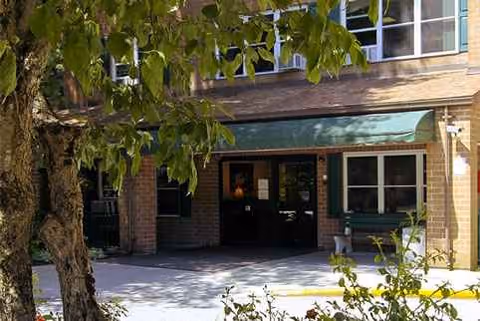 Exterior view of Morgan Rehabilitation and Healthcare Center entrance with green awning and trees.